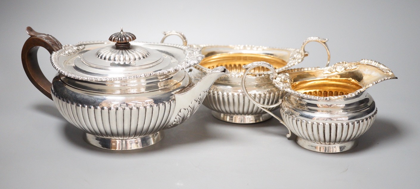 A late Victorian demi-fluted silver circular three piece tea set, Walter & John Barnard, London, 1895